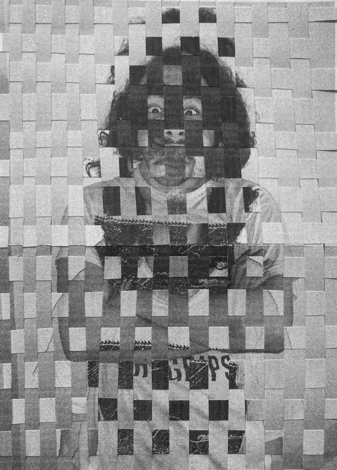 A self-portrait woven from strips of a printed photograph, in a tight over-under grid. A face with curly hair, wide eyes, and a mustache looks out through the weave, wearing a striped shirt and holding a card with partial lettering.
